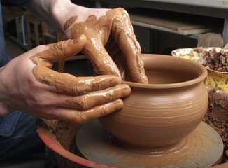 hands of a potter, creating an earthen jar on the circle