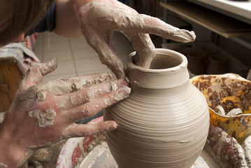hands of a potter, creating an earthen jar on the circle