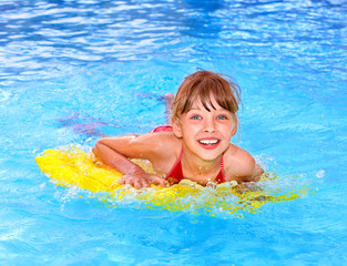 Fototapeta na wymiar Child swimming on inflatable beach mattress.