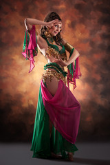 Beautiful exotic belly dancer woman a rot-green costume