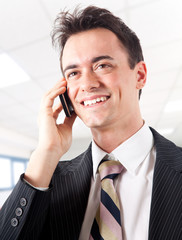 Smiling businessman talking at the phone