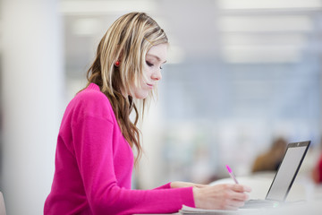 in the library - pretty female student with laptop