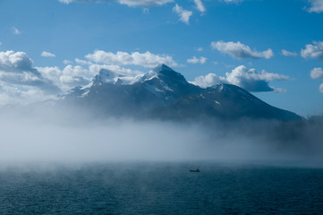 Canoeist in mist on mountain lake
