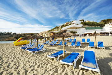 hamacas y sombrillas en una playa de ibiza al atardecer