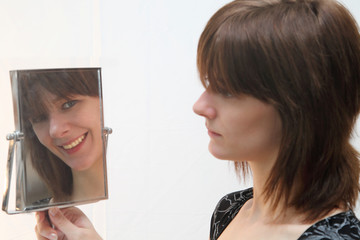A Pretty Brunnette Model Looking At Her Own Changing Reflection
