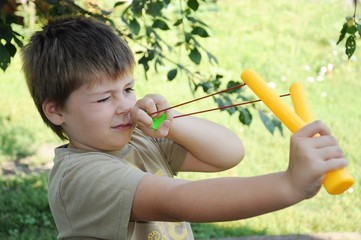 A boy plays with a left-handed catapult