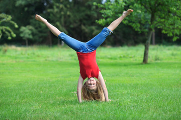 girl doing cartwheel outdoor smiling