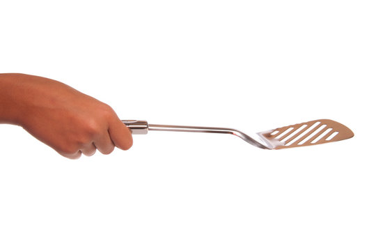 main qui tient une spatule en inox