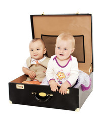 Portrait of two kids sitting in the suitcase
