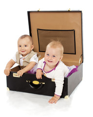 Portrait of two kids sitting in the suitcase