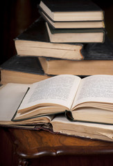 Pile old books and ancient lamp on dark and light background