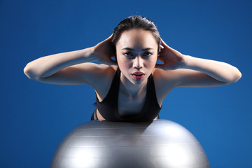 Oriental Asian woman back stretch on exercise ball