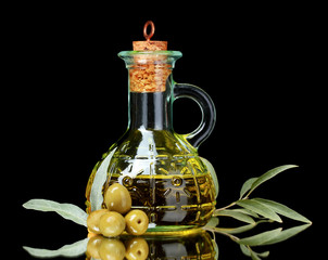 olive oil in jar and olives on black background