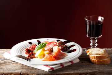 gemischte italienische Antipasti auf einem Teller mit Wein