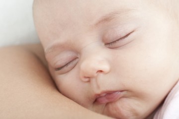 newborn sleeping on the mother shoulder