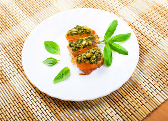 Slices of a salmon baked under a crust from sauce pesto
