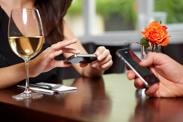 Hände mit Handys im Restaurant