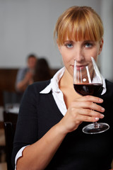 Frau riecht an Glas Rotwein
