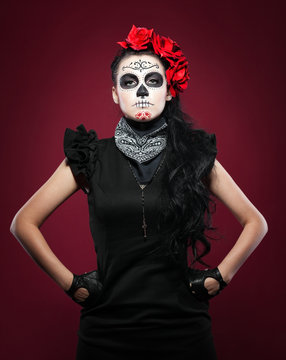 Young girl in day of the dead mask on red