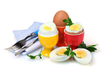 Boiled eggs in bright stands and cutlery isolated on white
