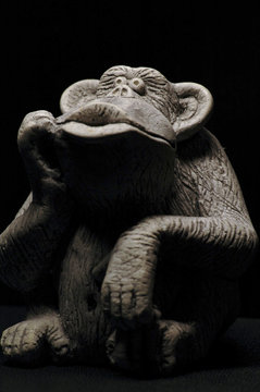 Thunking gorilla in front of a black background