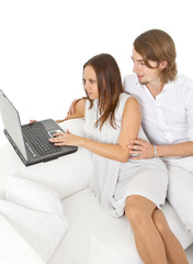 Naklejka premium Young european couple surfing the web at home