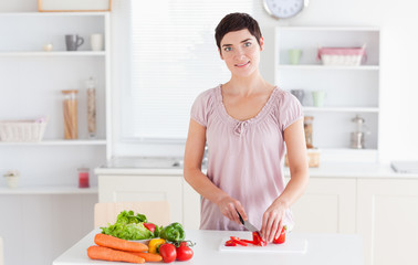 Smiling woman slicing vegetables