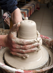hands of a potter, creating an earthen jar on the circle