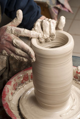 hands of a potter, creating an earthen jar on the circle