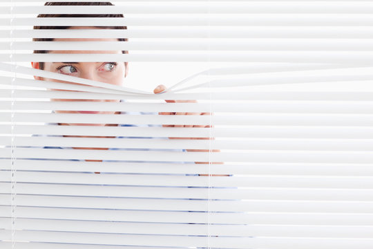 Curious Businesswoman Peeking Out Of A Window