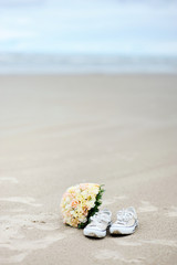 Wedding on a beach: flowers and a pair of sneakers