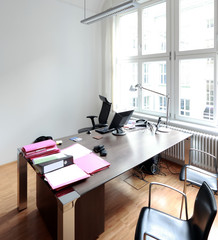 Aufgeräumter Schreibtisch mit weisser Wand im Büro