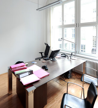 Aufger&auml;umter Schreibtisch mit weisser Wand im B&uuml;ro