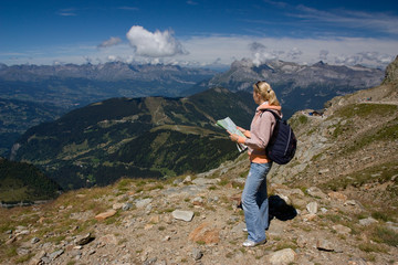 Woman tourist in mountain look at the map