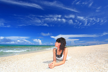 Fototapeta na wymiar コマカ島の砂浜でリラックスする女性