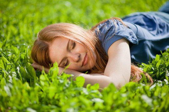 girl lying on the grass and sleeping peacefully