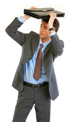 Scared young businessman holding briefcase over  head