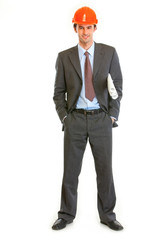 Full length portrait of businessman in helmet holding plan