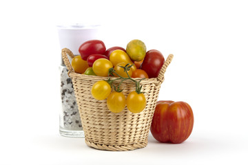 Korb mit zahlreichen Biotomaten und Pfeffermühle