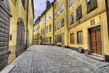 Fototapeta premium Old cobblestone street with yellow houses.