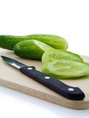 Sliced cucumbers and knife on chopping board