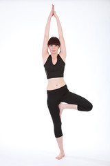 Beautiful fit woman in Yoga Tree Pose Vrksasana