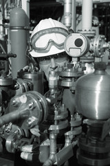 oil worker behind pipeline machinery