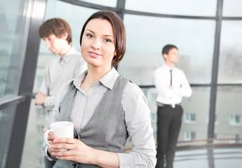 Obraz premium Portrait of a cute business woman with colleagues at the backgro