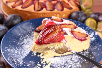 Plum pie being eaten with a fork