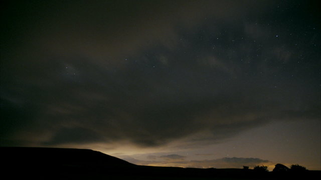 Dramatic time-lapse of clouds and stars in the night sky
