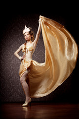 Fototapeta premium Woman in a luxurious style with flying fabric