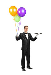 Butler holding an empty tray and balloons