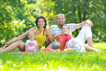 Fototapeta premium happy young couple with their children have fun at park