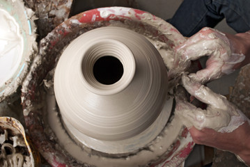 hands of a potter, creating an earthen jar on the circle © grthirteen